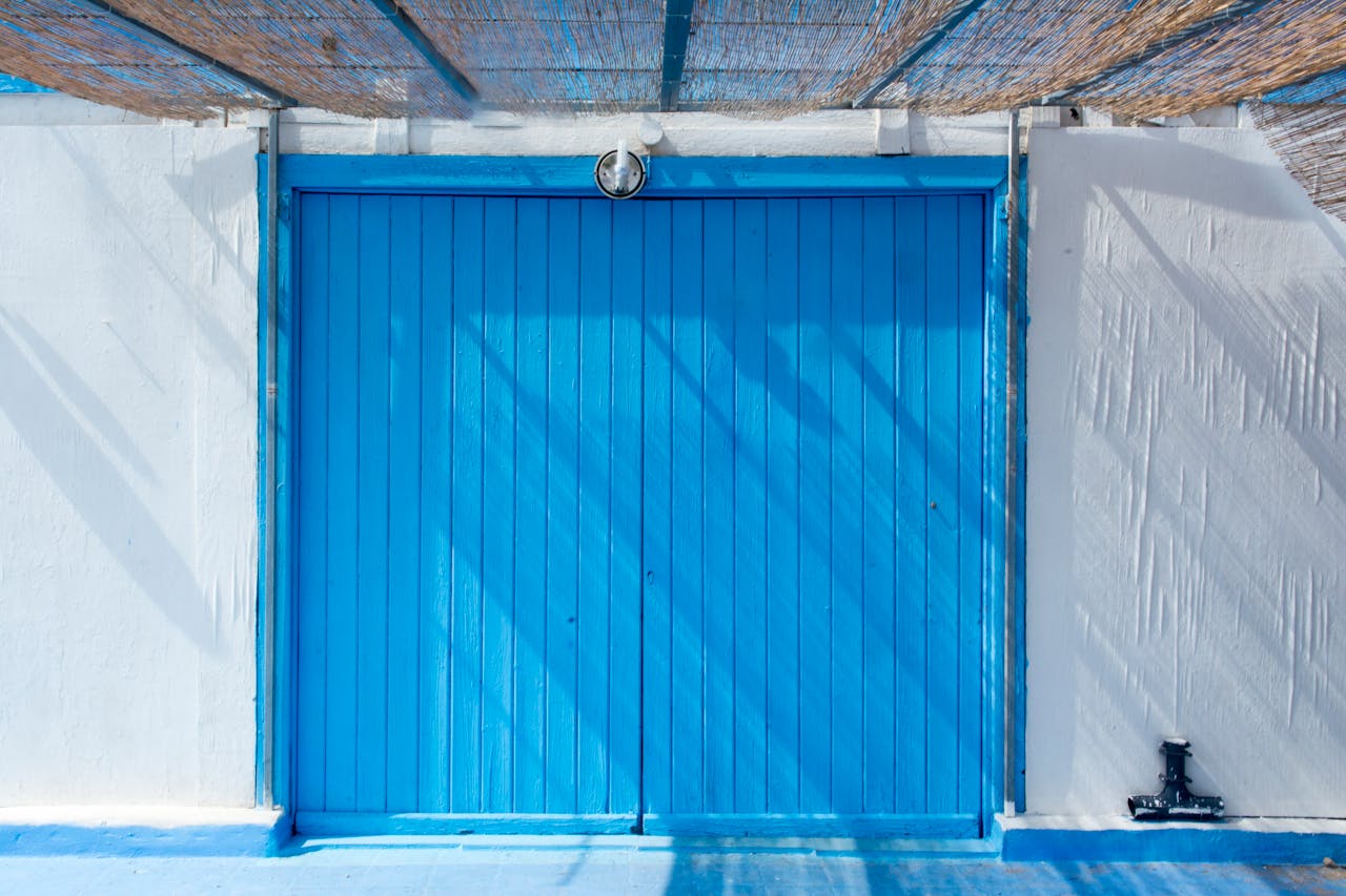 services-02 A vibrant blue wooden door in an urban setting, capturing rustic charm with sunlight and shadows.