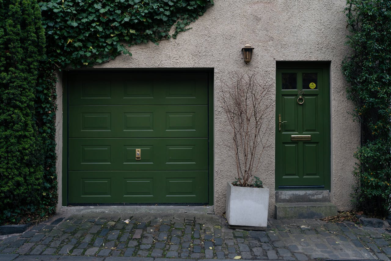 hero-img-01 Elegant green door and garage in Edinburgh with climbing ivy creating a serene facade.