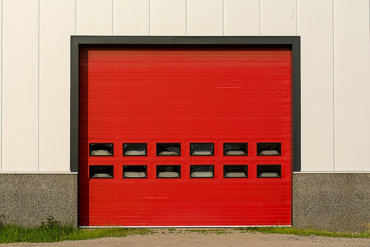 gallery-2 Bright red roller shutter garage door on industrial building exterior.